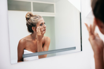 crème visage femme devant miroir