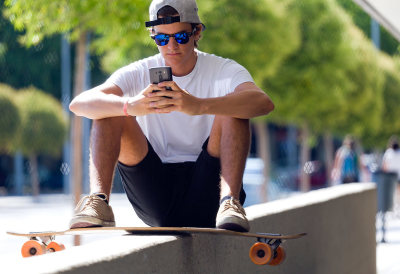 adolescent sur skateboard et avec smartphone